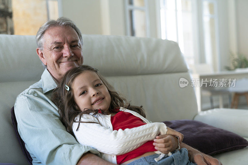 老人和孙女坐在家里沙发上的照片