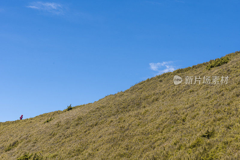 徒步旅行者独自走在山顶上。