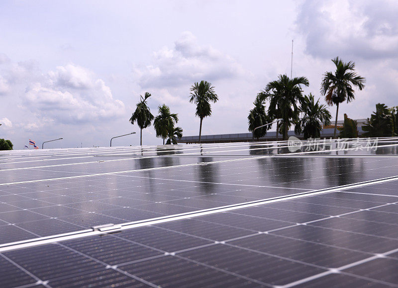 安装在建筑物屋顶上的蓝色光伏太阳能电池板，在日落时产生清洁的生态电力。生产可再生能源的理念。
