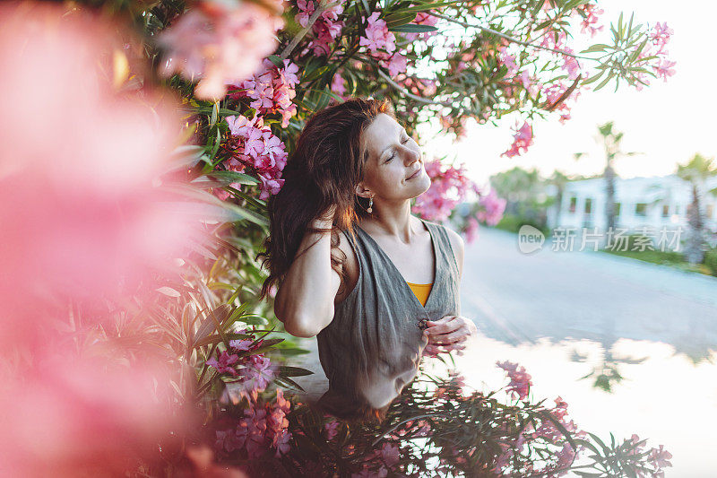 年轻的成年妇女夏季肖像在粉红色的开花树