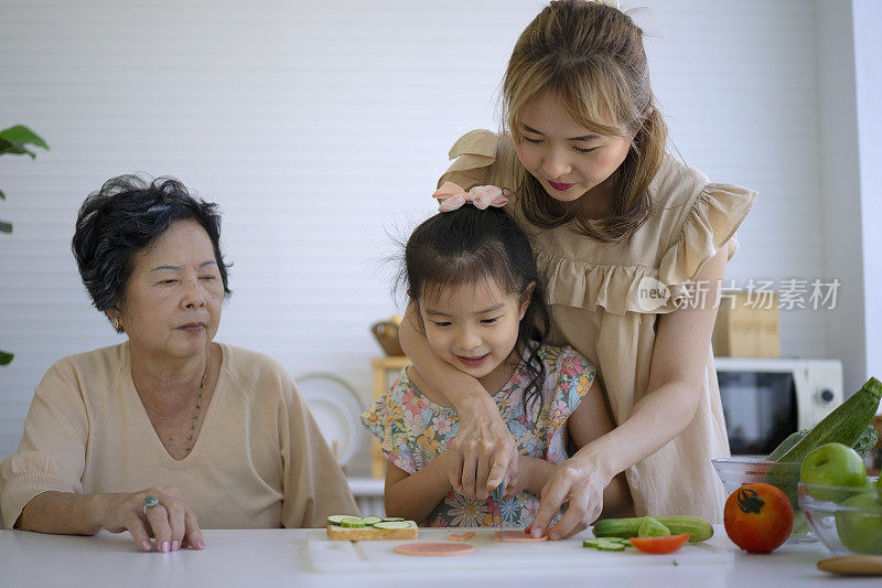 奶奶、妈妈和孙女在厨房准备食物。