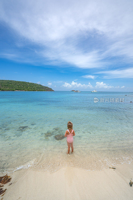 在美属维尔京群岛的热带加勒比海圣约翰岛上，一个孩子在美丽幽静的盐塘海滩上玩耍