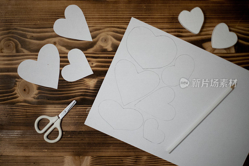 手工雕刻diy心形白色复印纸。为情人节准备工艺品。情人节礼物创意，爱的日子，2月14日的概念。一步一步来。工艺过程。情人节卡片