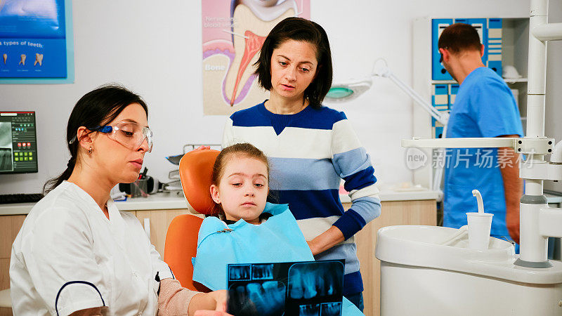 儿科牙医拿着x光片显示牙齿问题