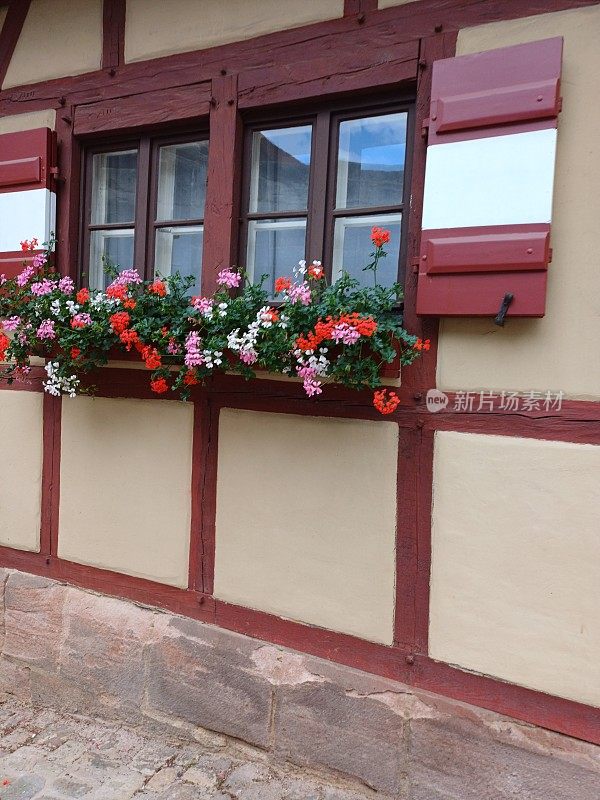 上午，在德国巴伐利亚州纽伦堡老城区，一所房子的窗户上挂着鲜花。