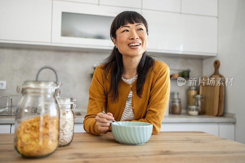 一位日本妇女享受着她的早晨习惯，早餐吃玉米片加牛奶