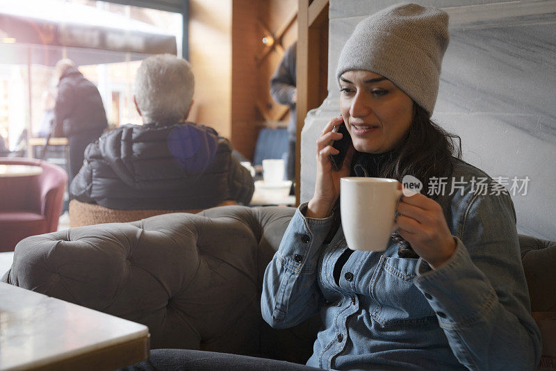 一个女人在咖啡馆用手机
