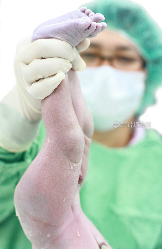 亚洲外科医生抱着一个刚出生的男婴