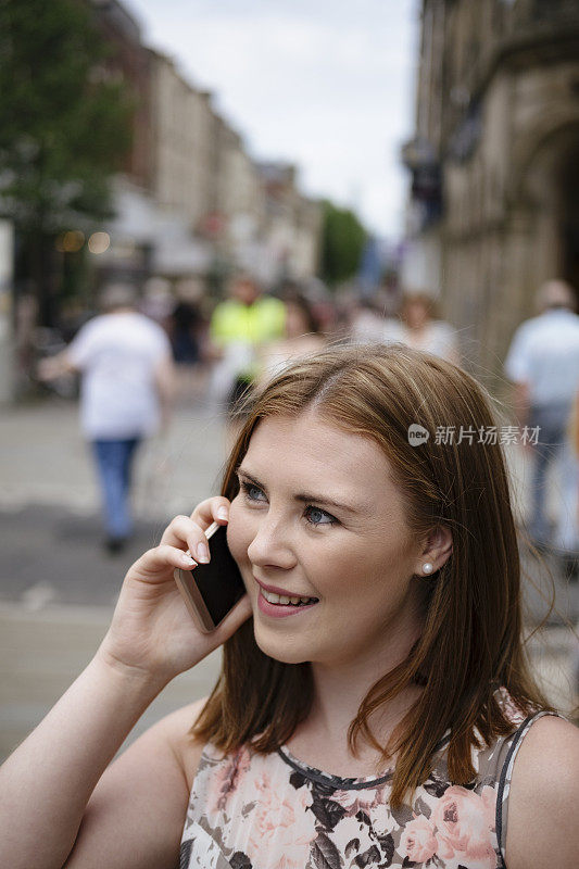 一名年轻女子在英国市中心玩手机
