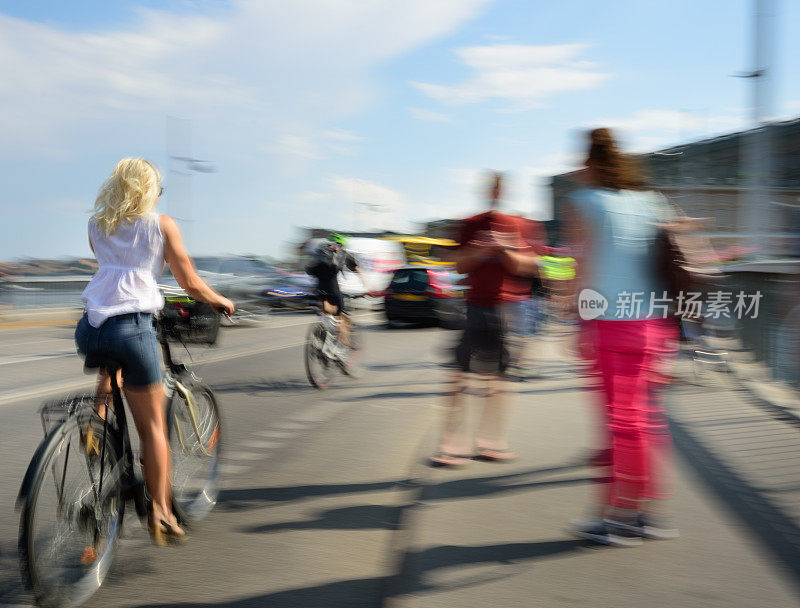 在城市里骑自行车的瑞典金发女人