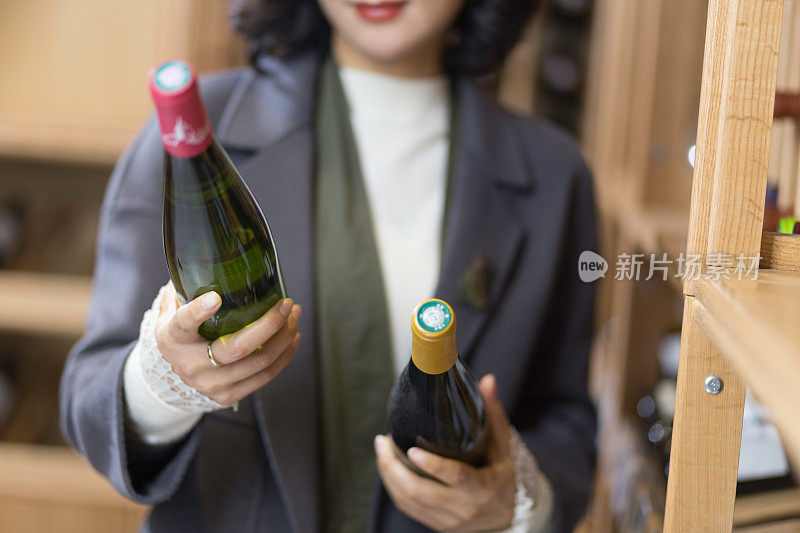 年轻的亚洲女子拿着红酒