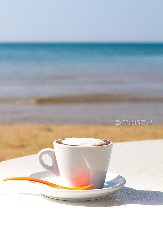 海滩上的卡布奇诺:美丽的沙滩和大海的背景