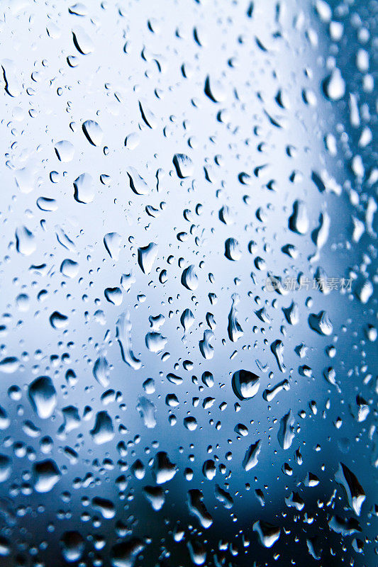 雨滴落在蓝色的玻璃上