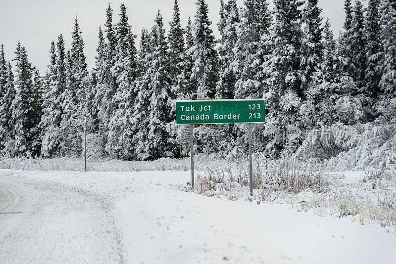 阿拉斯加冬季路和森林与加拿大边境路标志