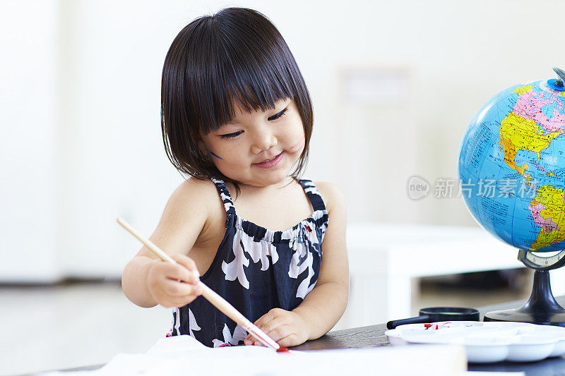 可爱的亚洲小女孩在室内画画
