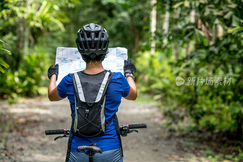 女人骑着山地车拿着地图