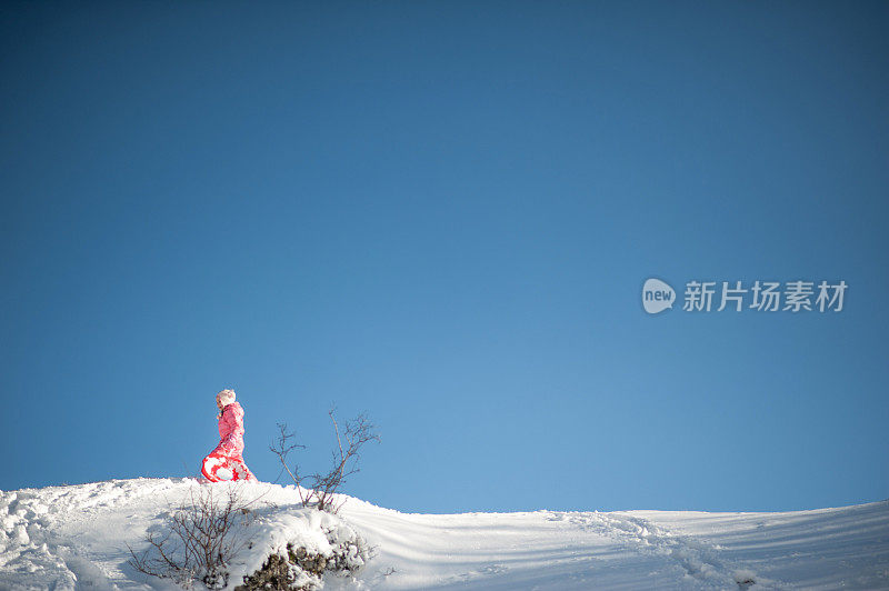 在雪地里玩雪橇的孩子