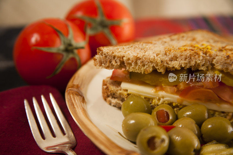 新鲜的三明治。奶酪，西红柿，泡菜，面包上的橄榄。