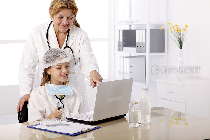 穿着医生制服的年轻女孩在看笔记本电脑。