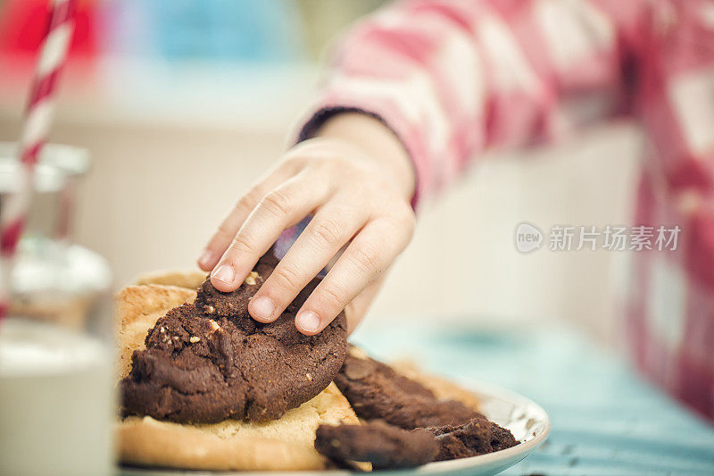 小女孩从盘子里拿巧克力饼干