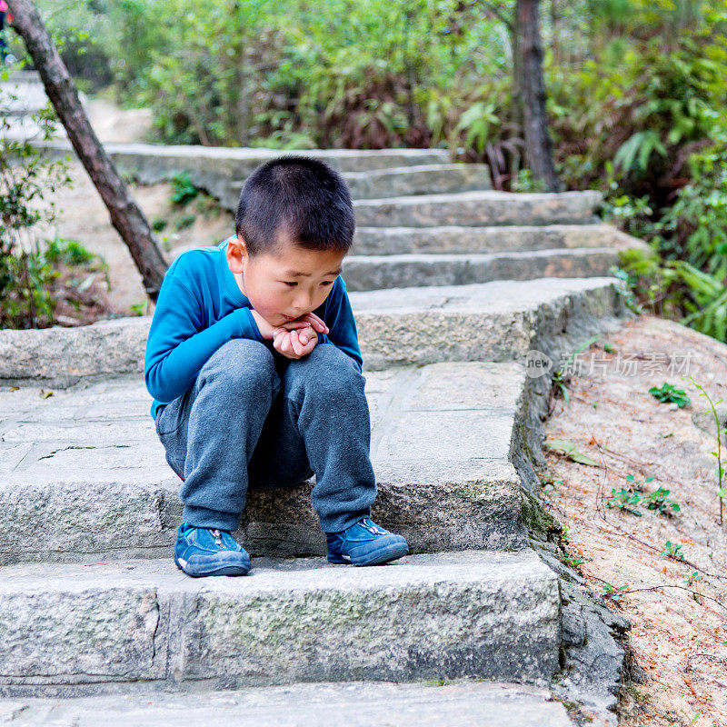 小男孩坐在楼梯上