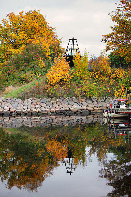 秋天的树木在运河和船