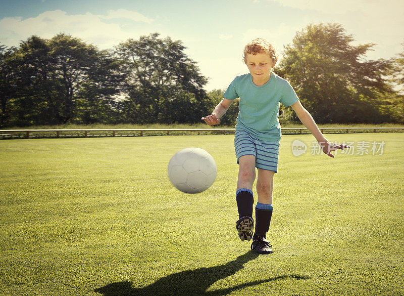 男孩用球训练足球