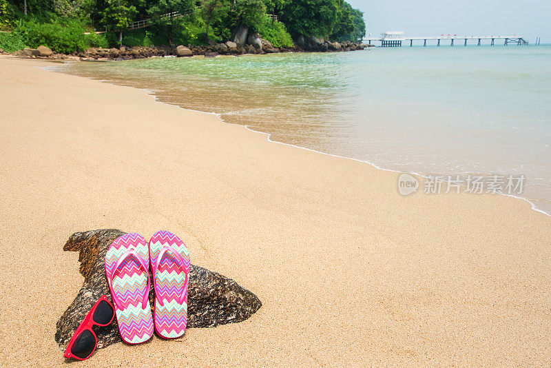 热带海滩上的红凉鞋和太阳镜