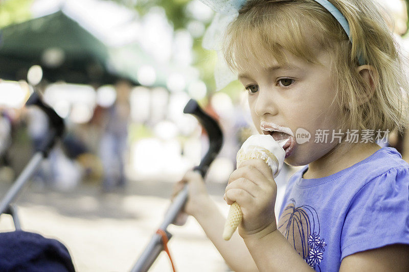 可爱的小女孩吃冰淇淋蛋卷