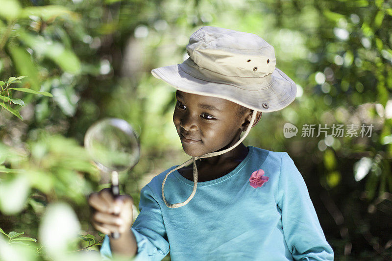 一个非洲女孩用放大镜看东西