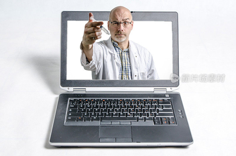 笔记本电脑和一个拿着注射器的男医生在他面前