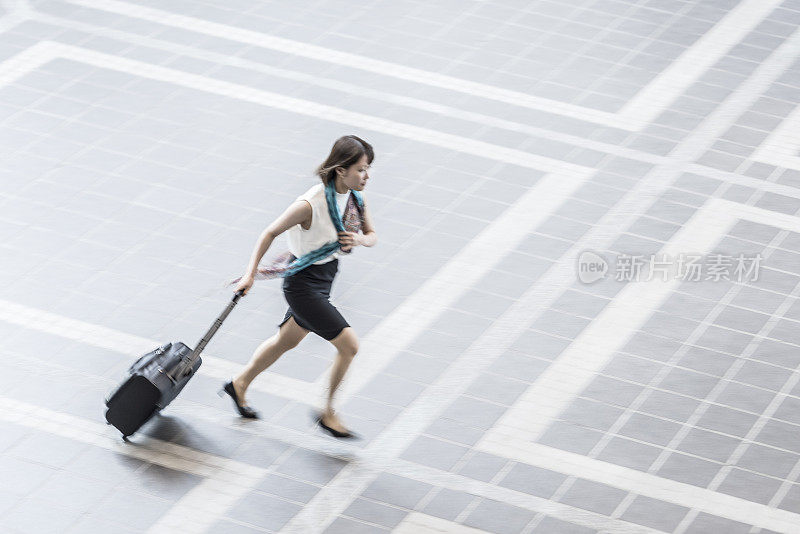 日本女商人跑着滚动的行李