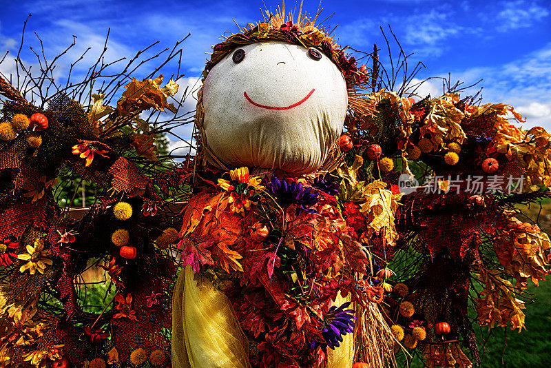 五颜六色的秋天稻草人，脸上挂着快乐的表情