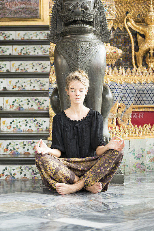 女游客在泰国曼谷大皇宫冥想