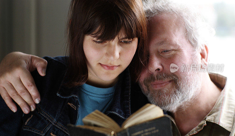 父亲和女儿一起读旧书