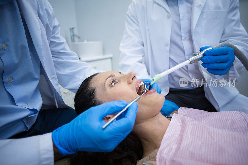 牙医用工具检查一位女病人