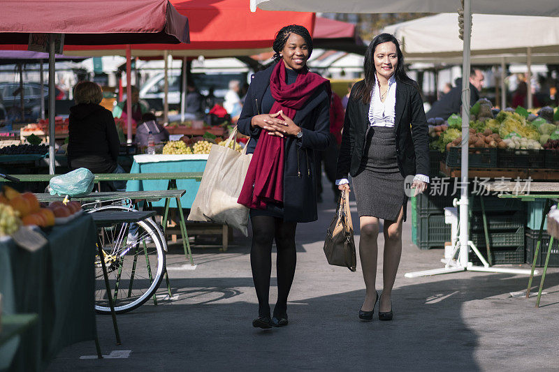 两个中年女商人正穿过街市