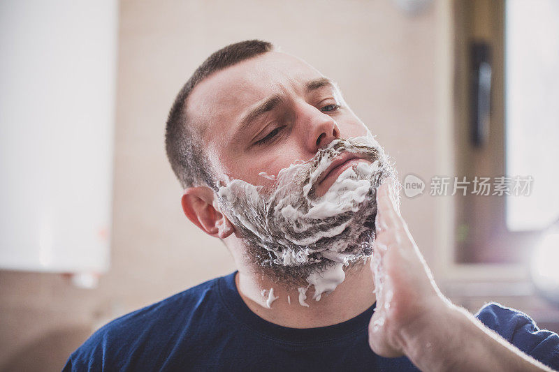 男子在胡子上涂剃须膏
