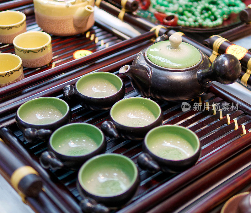 木制三脚架上的中国白色茶壶和茶杯