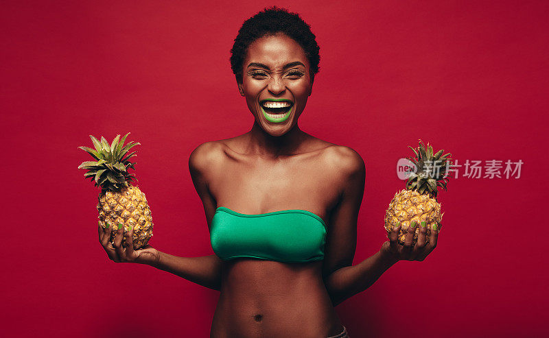 拿着菠萝大笑的非洲女人