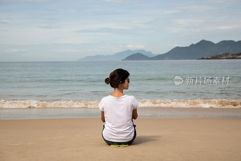 美丽的女人注视着平静的大海。