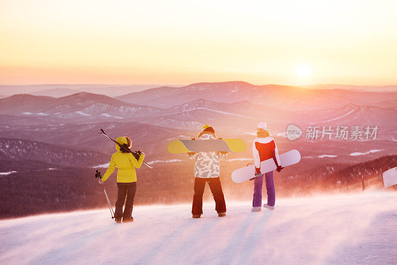 夕阳下滑雪胜地的朋友们