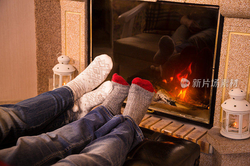 腿在羊毛袜加热靠近壁炉，温暖的色调