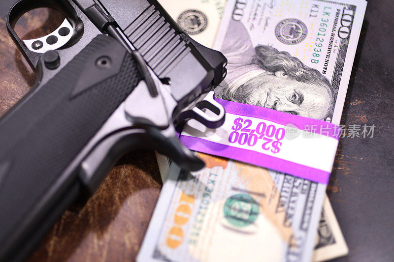 9毫米手枪和一堆装在2000美元包装里的100美元钞票。