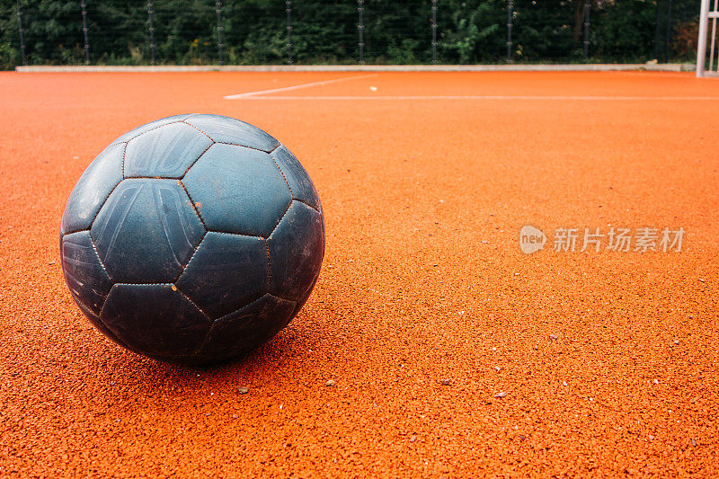 橙色地面上没有任何标志的蓝色旧足球