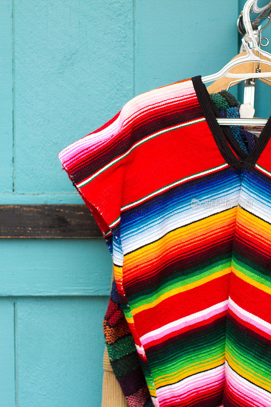 传统充满活力的墨西哥条纹羊毛雨披;青绿色的背景