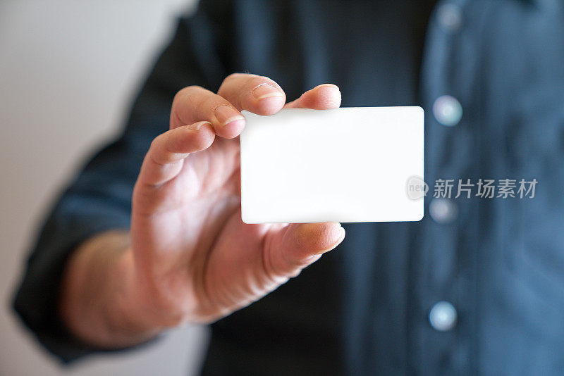 手持空白白色信用卡模型正面侧视图。塑料银行卡设计模拟