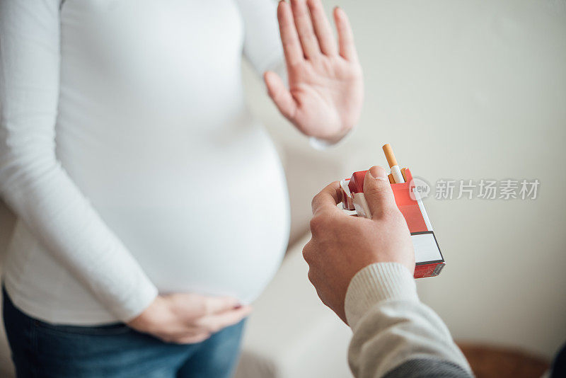 抱着孕肚拒绝吸烟的孕妇