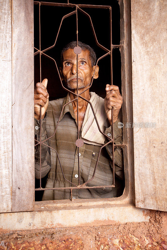 一位沉思的印度农村老人从窗户往外看