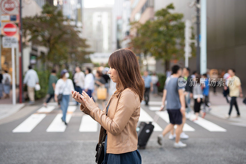 一个女人在购物街上看手机